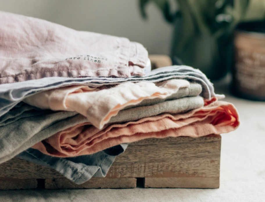 stack of pure linen fabrics on wood tray