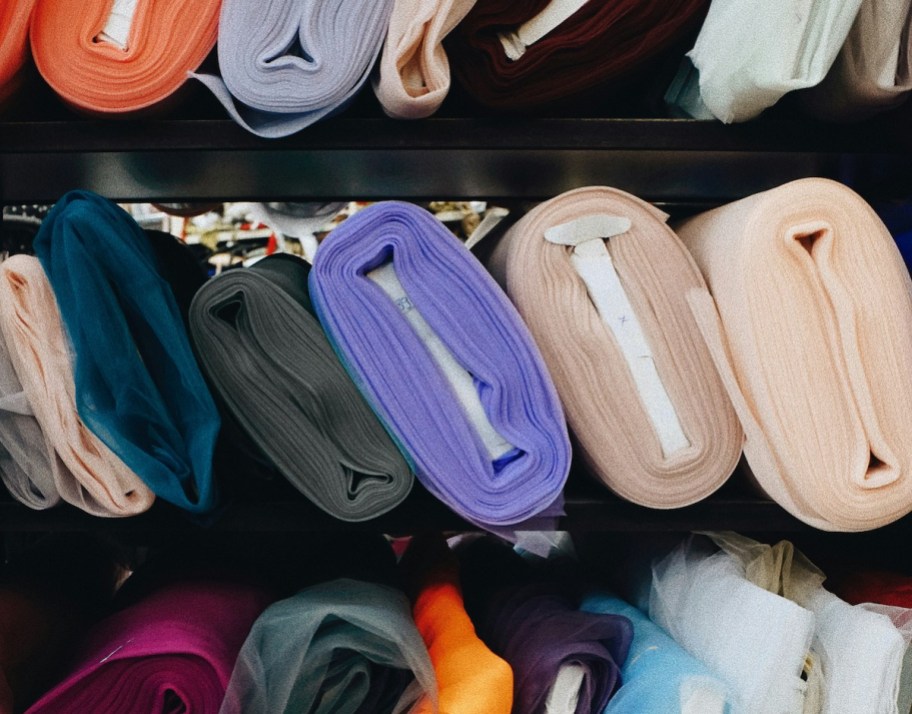 rolls of various fabrics on shelf