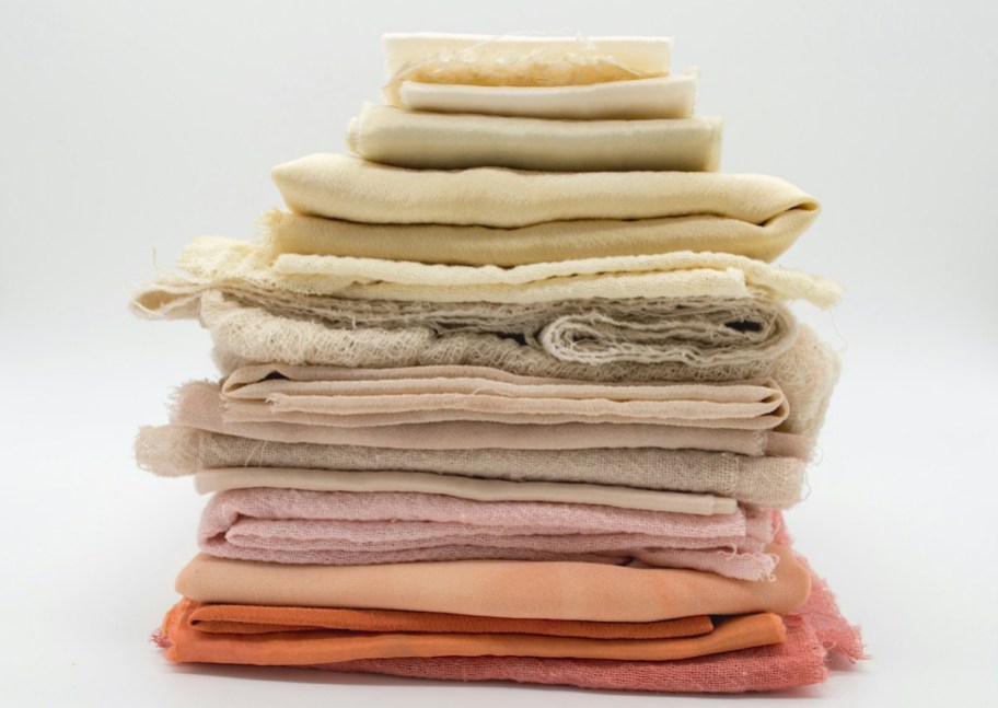 stack of orange pink and yellow fabrics