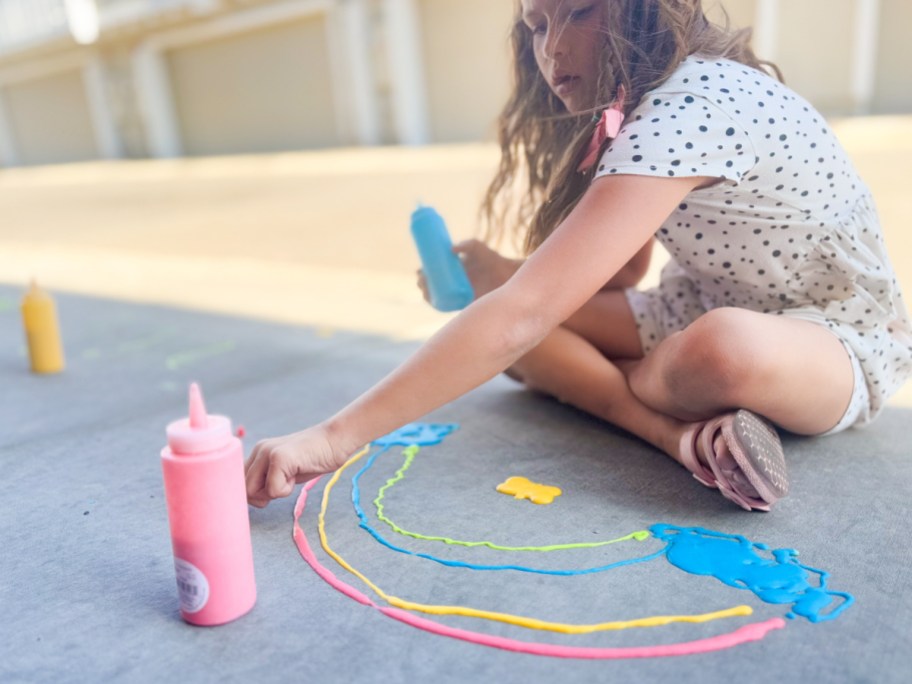 girl on sidewalk painting with puffy paint