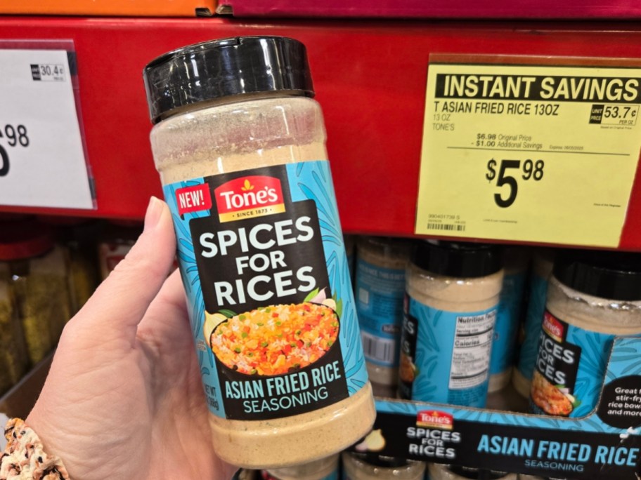 hand holding a container of Tone's Spices for Rices seasoning in a store aisle