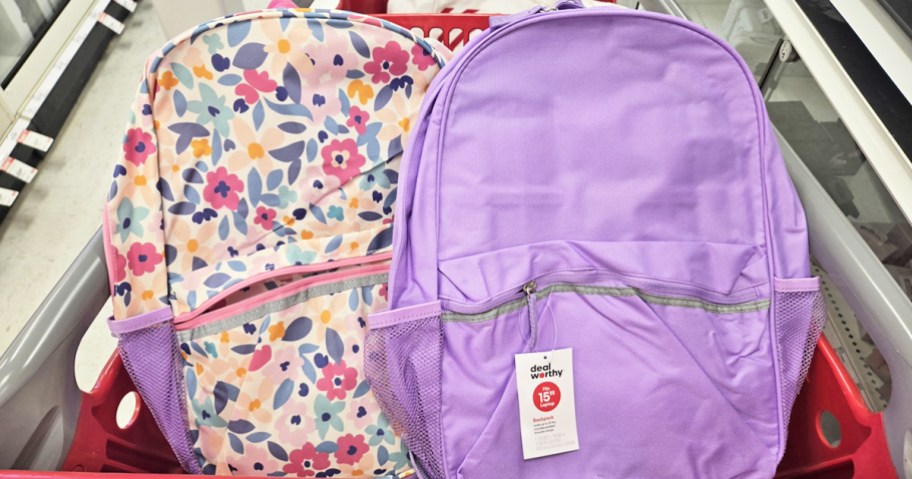 floral print and solid purple backpacks in a red shopping cart